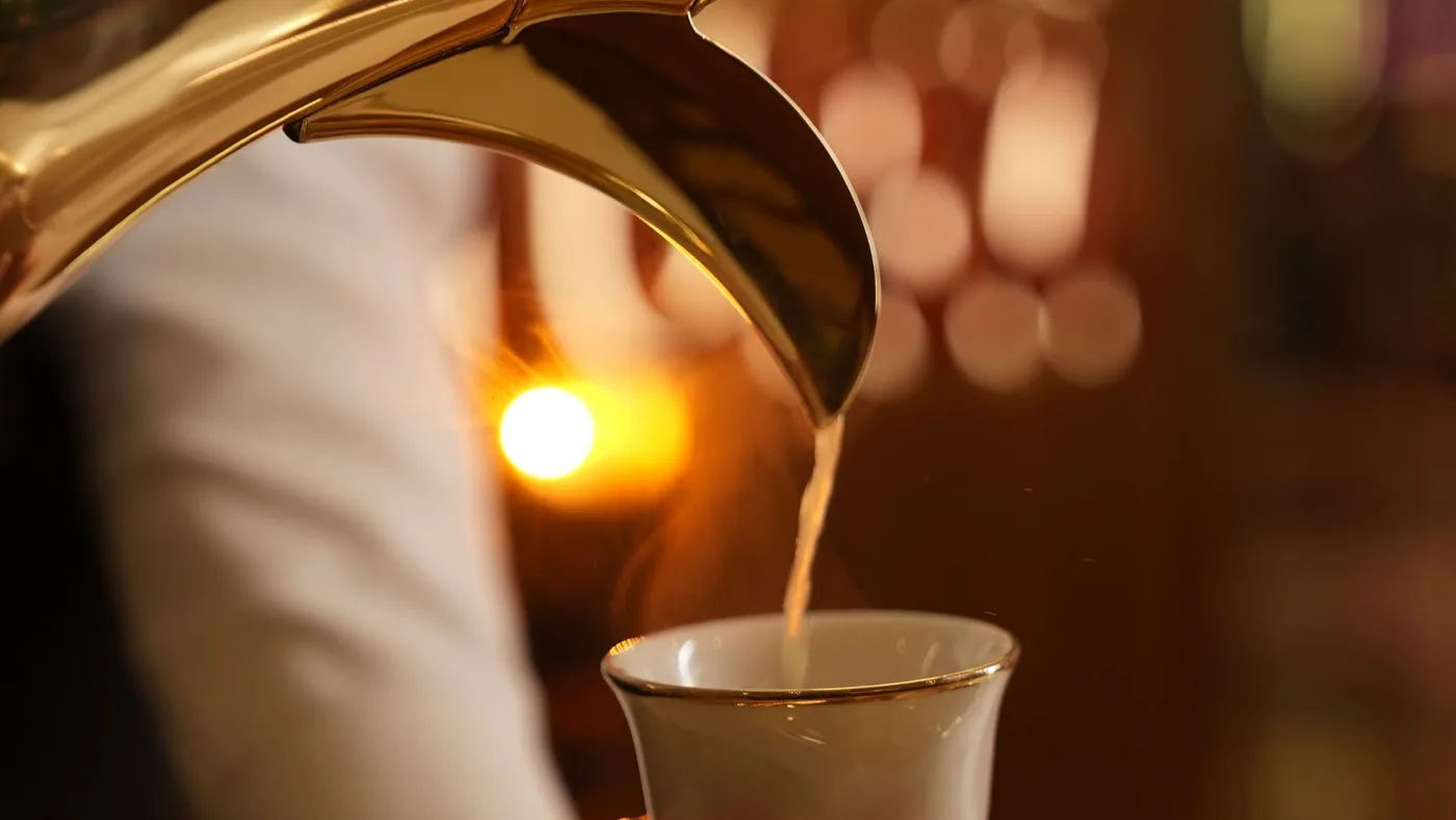 صبّ القهوة السعودية من الدلة في الفنجان
